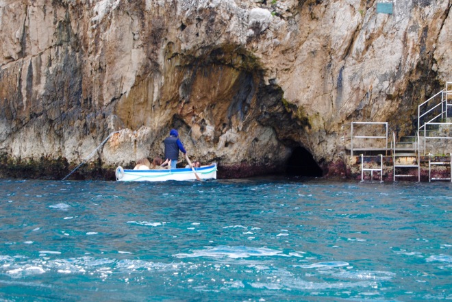 The small hole to the right of the row boat is the entrance to the Blue Grotto.